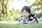 Closeup happy asian kid lied on grass floor in the garden background with cute motion