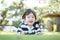 Closeup happy asian kid lied on grass floor in the garden background with cute motion