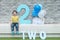 Closeup happy asian kid sit on marble bench on brick wall background in 2 nd years anniversary concept