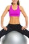 Closeup on happy fitness young woman sitting on fitness ball