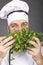 Closeup of happy young chef smelling parsley