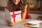 Closeup on happy young housewife reading christmas postcard