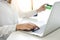 Closeup of happy young woman holding credit card inputting information while and using laptop computer at home. Online shopping c