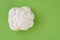 Closeup of head of cauliflower on a green cutting board