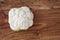 Closeup of head of cauliflower on a rustic wood cutting board