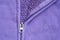 Closeup head of zipper at purple jacket textured background