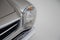 Closeup of the headlight of a silver vintage car under the lights isolated on a grey background