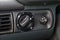 Closeup of a headlight tilt adjustment knob on a black old plastic panel of a Russian car with white signs