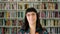 Closeup headshot of young woman showing a content facial expression in school library or community centre. Portrait of