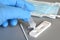 closeup of a healthcare worker hand in blue surgical gloves while taking a test for the covid-19 virus showing a negative result.