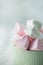 Closeup of heart shaped pink and white marshmallows in mintgreen cup