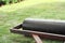 Closeup heavy steel drum for pressing the lawn field during growing the grass with blurred green landscape in background