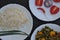 Closeup high angle view of rice, matar paneer mix veg and salad on white plate