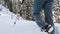 Closeup of hiking boots on a snow path.