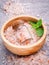 Closeup Himalayan pink salt in wooden bowl and bottle with pepp