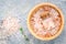 Closeup Himalayan pink salt in wooden bowl and bottle with thym