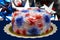 Closeup of a holiday cake with creamy sugary red white and blue swirls of icing sitting on a gold paper against a dark background