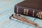 Closeup of Holy Bible Book with gold letters on wooden background with rusty nails. Jesus Christ sacrifice.