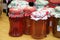 A closeup of homemade jam in nicely wrapped jars at a market