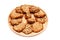 Closeup homemade natural oatmeal dietary lean cookies with seeds on a round wooden plate isolated on a white background. The