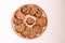 Closeup homemade natural oatmeal dietary lean cookies with seeds on a round wooden plate isolated on a white background. The