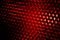 Closeup honeycomb grid texture with red light. Red and dark metal hexagon shaped pattern abstract background. Light modifier