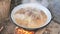 Closeup of hot bubbling boiling water with meat and bones in a deep fryer.