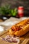 Closeup of a hot dog with pure beef sausage with onions on a wooden board.