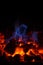 Closeup of hot red embers and blue flame in fireplace