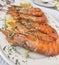 Closeup of a hot steamed shrimp dish, gambas a la plancha, served on a white plate