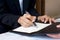 Closeup hotel manager hand holding pen, pointing at guest registration document