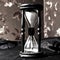 Closeup.hourglass with white sand on a wooden table