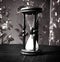 Closeup.hourglass with white sand on a wooden table