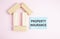 Closeup of house wooden model with blank for text on background. Property Insurance insurance