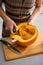 Closeup on housewife removing filling from pumpkin