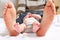 Closeup of huge feet of father and little newborn baby