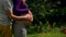 Closeup of human couple hands holding pregnant belly outdoors in summer park