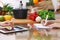 Closeup of human hands cooking in kitchen using touch pad. Women discuss a menu. Healthy meal, vegetarian food and