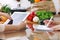 Closeup of human hands cooking in kitchen using touch pad. Women discuss a menu. Healthy meal, vegetarian food and