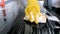 Closeup iamge of yougn woamn in rubber gloves washing electric stove with sponge and detergent