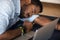 Closeup image African male worker falls asleep at workplace desk