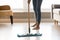 Closeup image barefoot girl doing house cleaning using wet mop