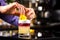 Closeup image of bartender hands decorating cocktail with lemon