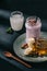 closeup image of berry smoothie, jam, banana slices and walnuts on plate, spoon, yogurt