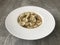 Closeup image of a bowl of cappelletti pasta against a wooden background