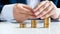 Closeup image of businessman sitting behind office desk with three stacks of golden coins