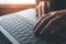 Closeup image of busineswoman working and typing on laptop keyboard on wooden table