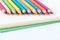 Closeup image of color pencils on the book and white background