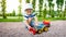 Closeup image of cute little boy playing on the palyground with toys. Child having fun with truck, excavator and trailer