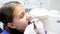 Closeup image of dentist hands in gloves examining girls teeth with instruments